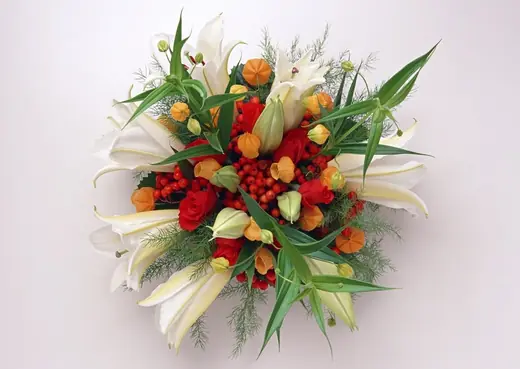 ช่อดอกไม้ทรงกลม กุหลาบแดง ลิลลี่ขาว และลูกไม้สีส้ม